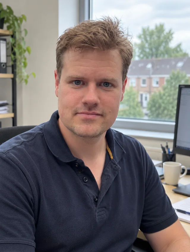 Stefan aan zijn bureau, met uitzicht op de straat achter hem